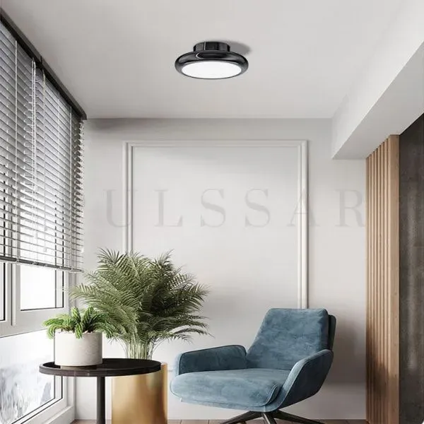 Плоский потолочный светильник, установленный над креслом, создает локальную зону с ярким и равномерным светом для комфортного чтения.